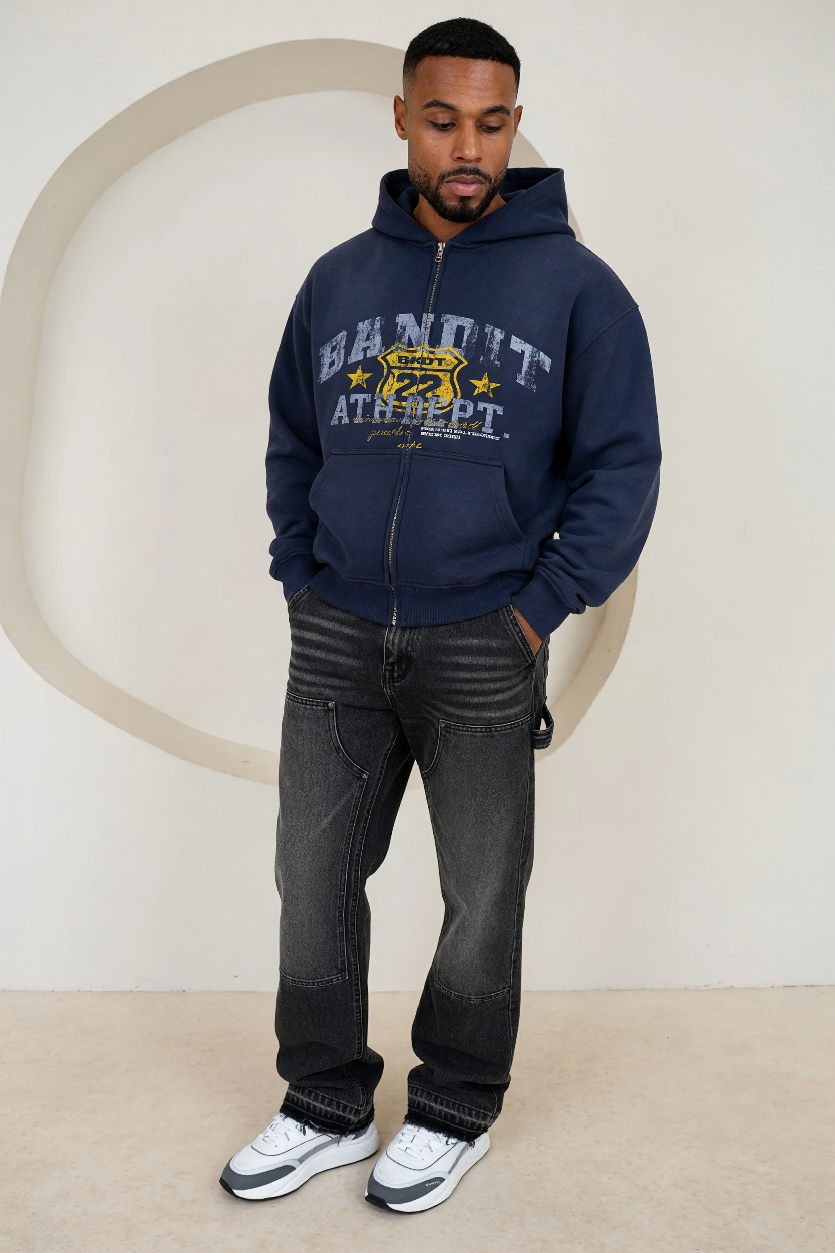 Generated on-model try-on — navy Bandit zip hoodie with washed carpenter jeans